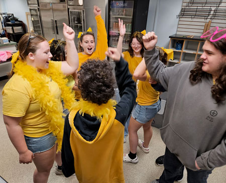 Go Team! Students in a group arms up